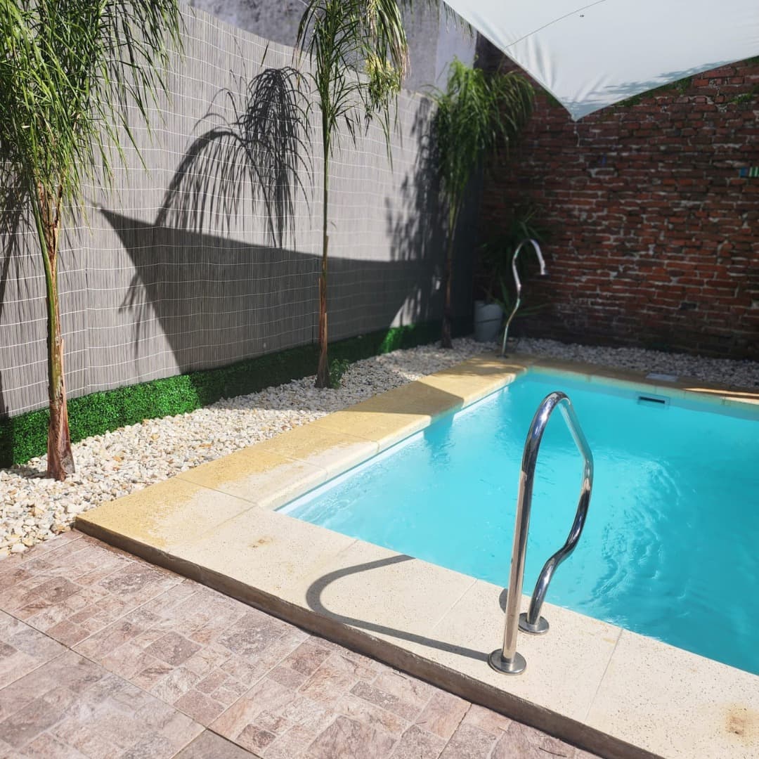 Piscina con pasamanos y deck claro
